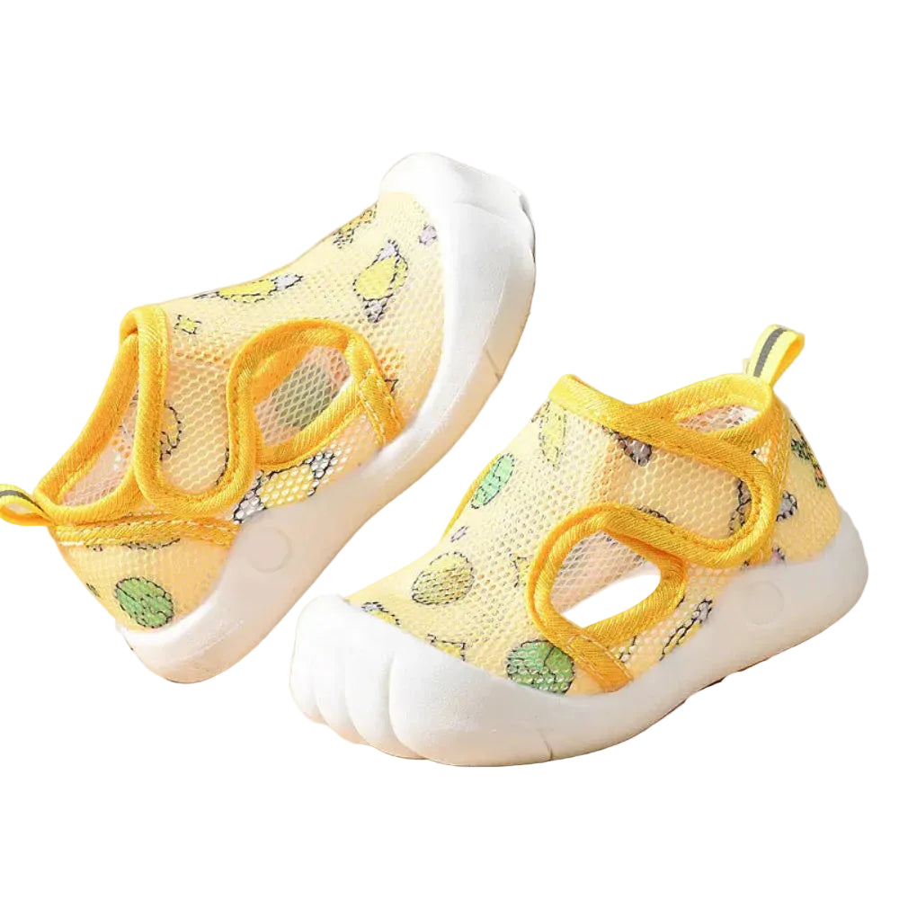 Yellow children's shoes with floral pattern on a beige background