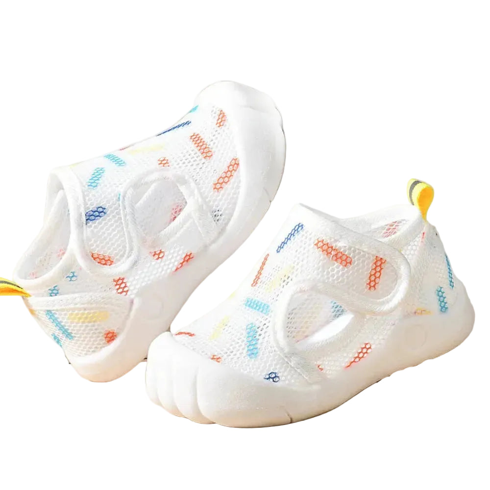 White children's shoes with colorful patterns on a light background