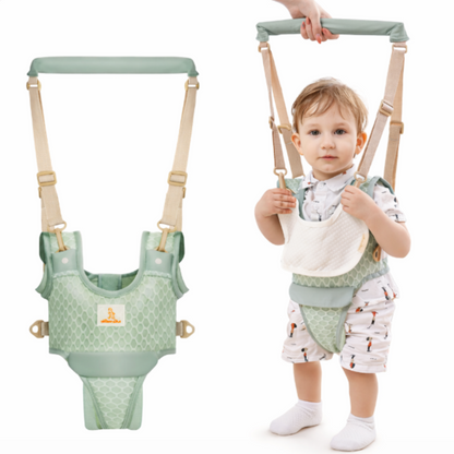 Baby in a green harness with a plain background