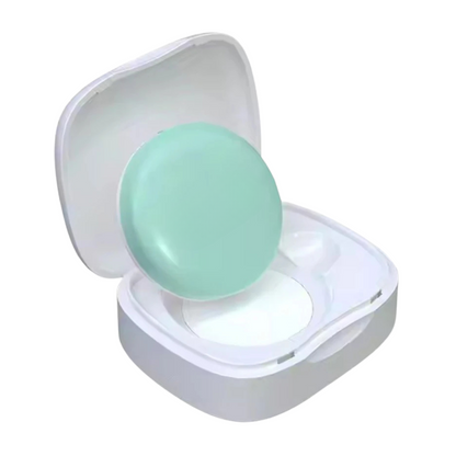 MomSafe SmartPatch wearable baby thermometer sensor inside charging case isolated on white background